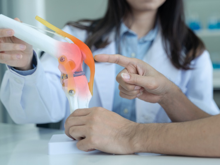 knee doctor explaining about knee conditions to a patient pointing at the patella