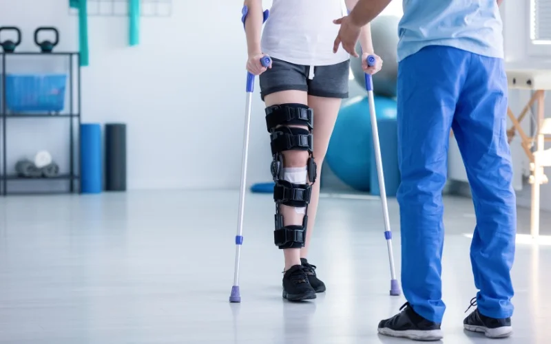 woman in knee brace and crutches for physical therapy