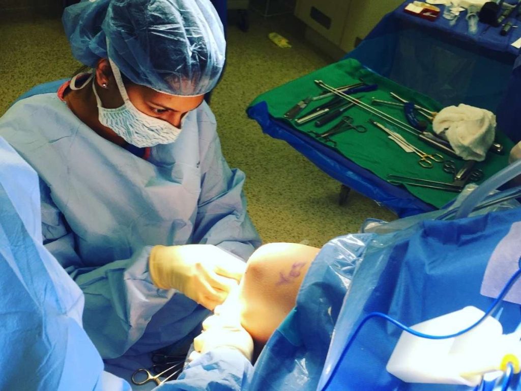 Surgeon closing knee wound