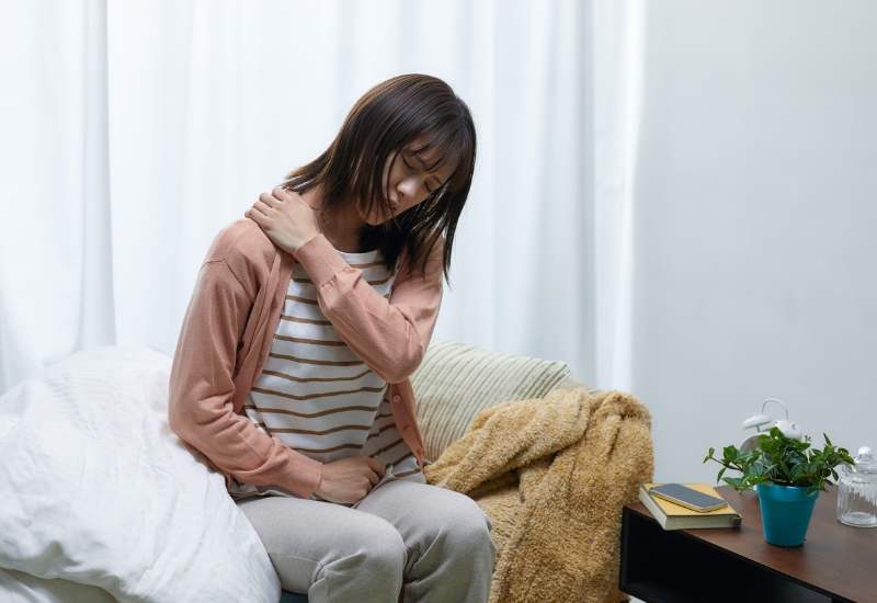 woman in pain holding her shoulder