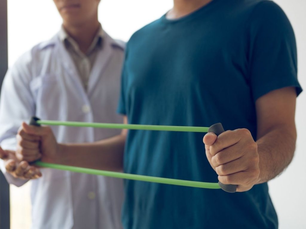 Image of a person with a physical therapist using resistance bands.