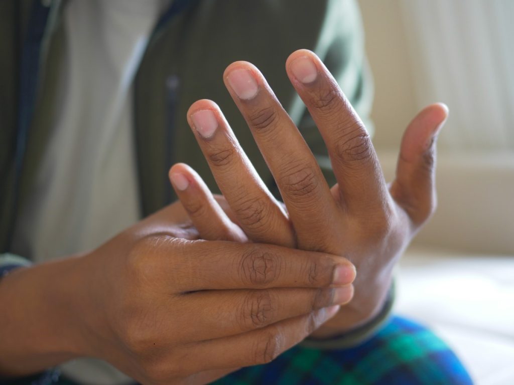Man holds his painful hand and fingers