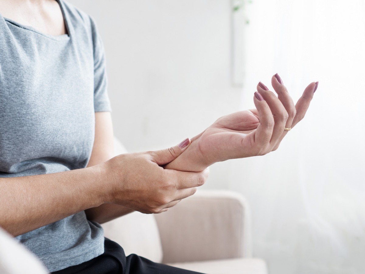 Woman holds her painful wrist