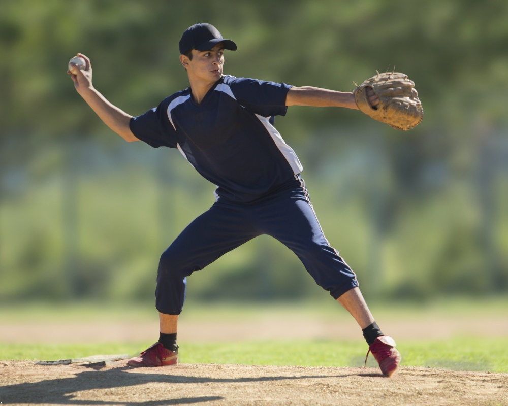 Teenager throwing baseball during a game
