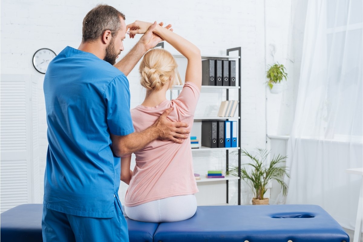 Male physiotherapist working with female client