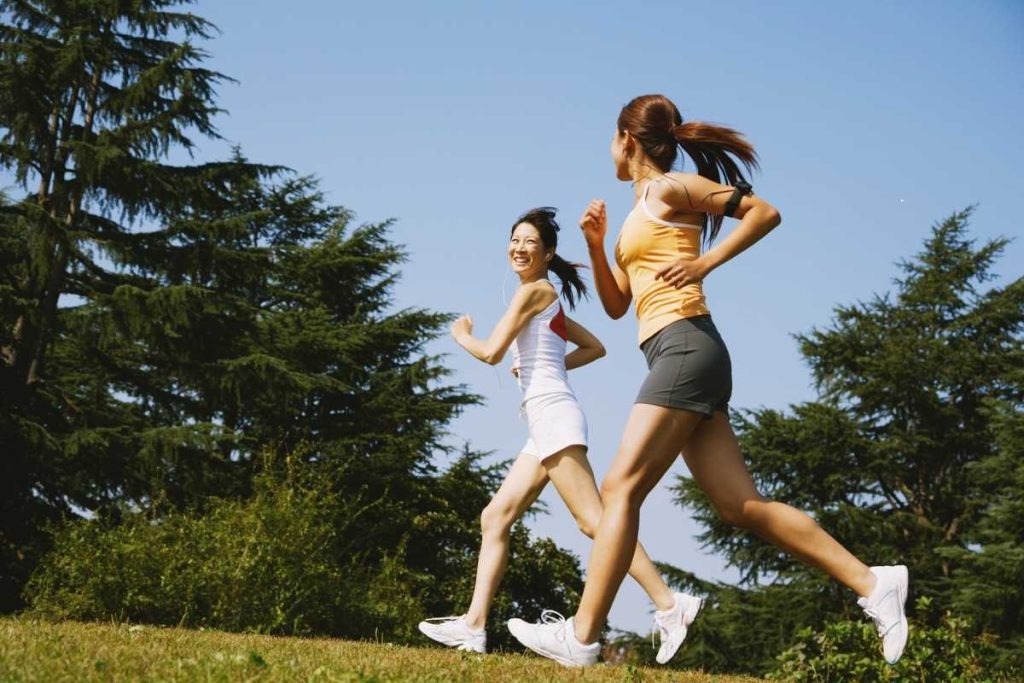 Two females on a jog surrounded by greenery