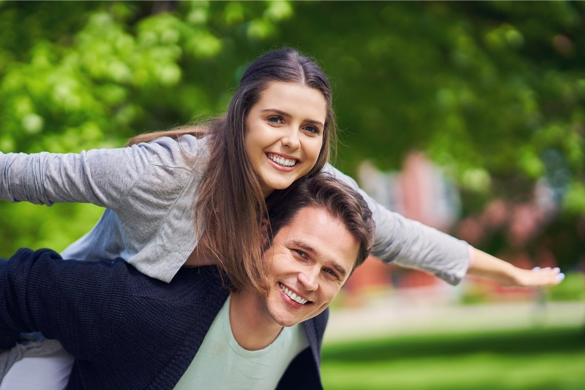 Woman and man smiling and having fun in the park