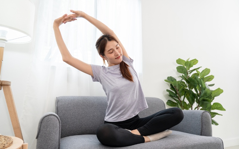 Woman lightly stretching on the sofa