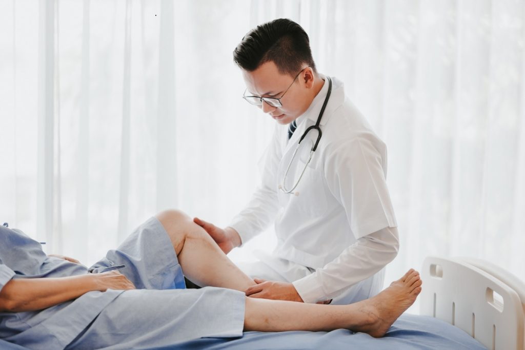 Doctor examining patients knee