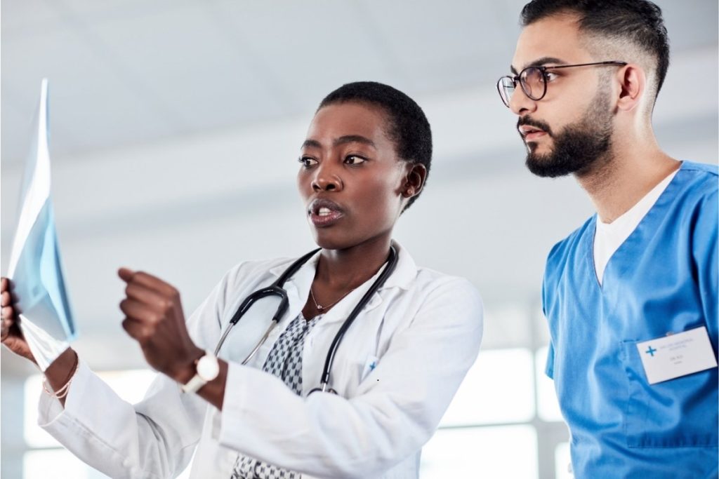 Female doctor and male surgeon reviewing x-ray results