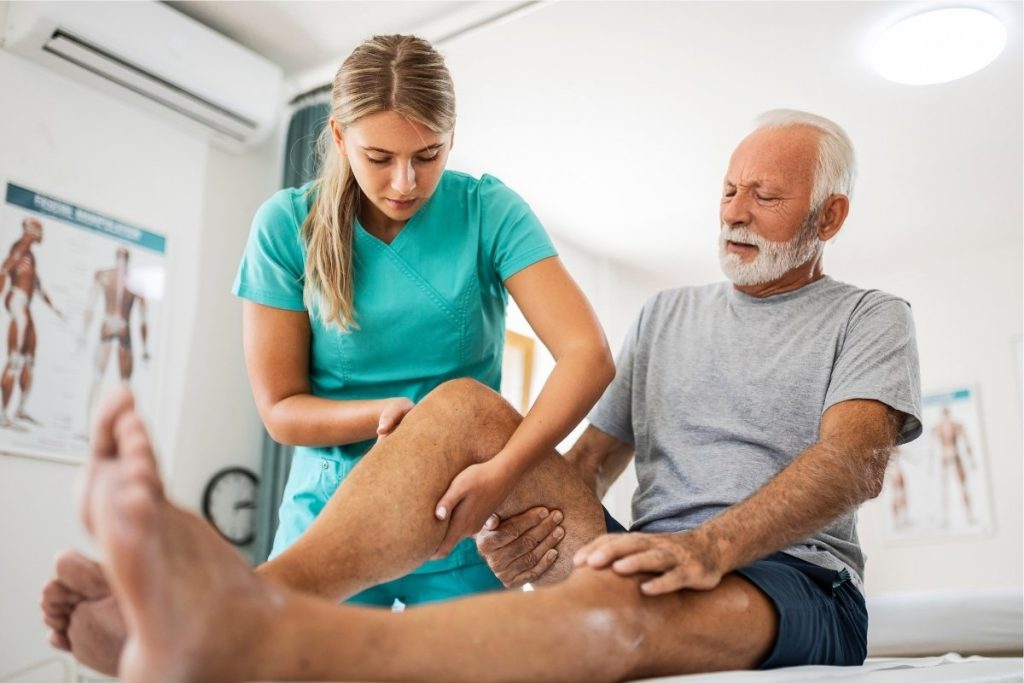 Female physical therapist with elderly male patient