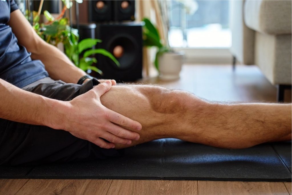 Male holds injured leg muscle (1)