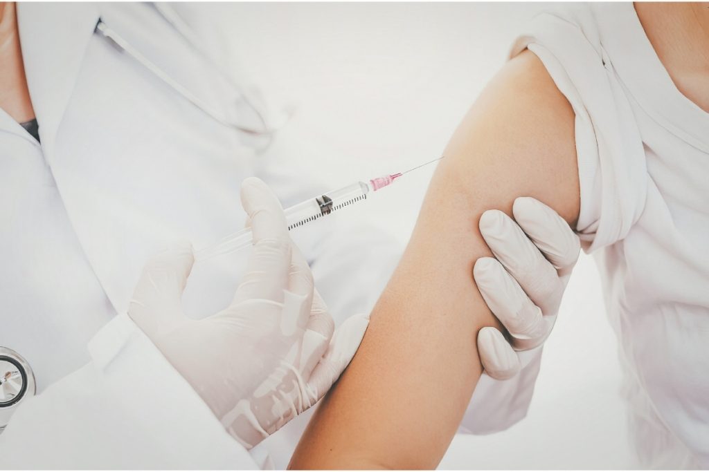 Doctor performing shoulder injection on patient