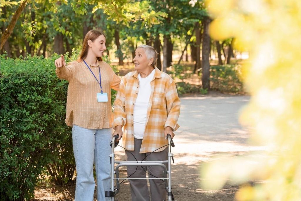 Female health worker with female patient and zimmer frame