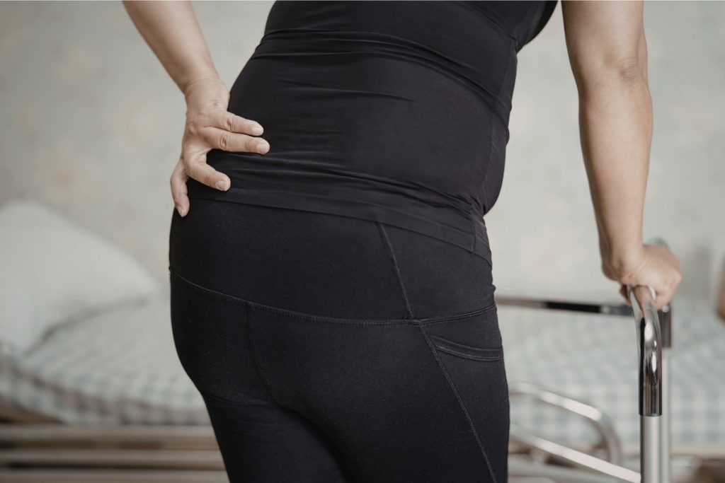 Person holding their hip whilst walking