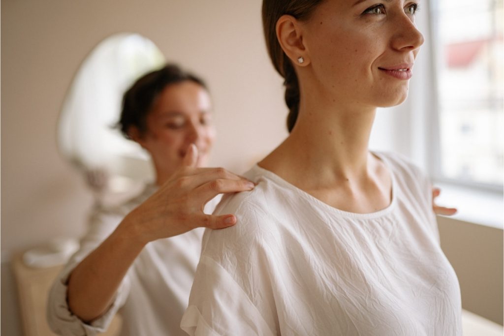 Female physical therapist treating female patient's shoulder (1)