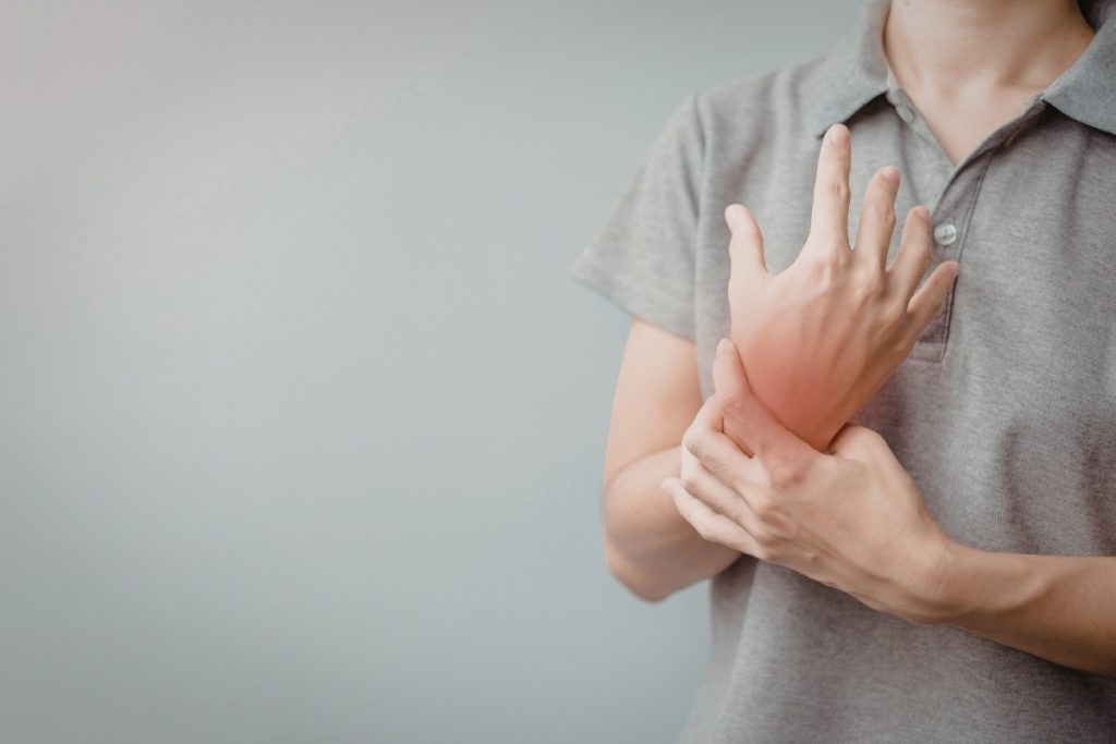 Male holds painful wrist