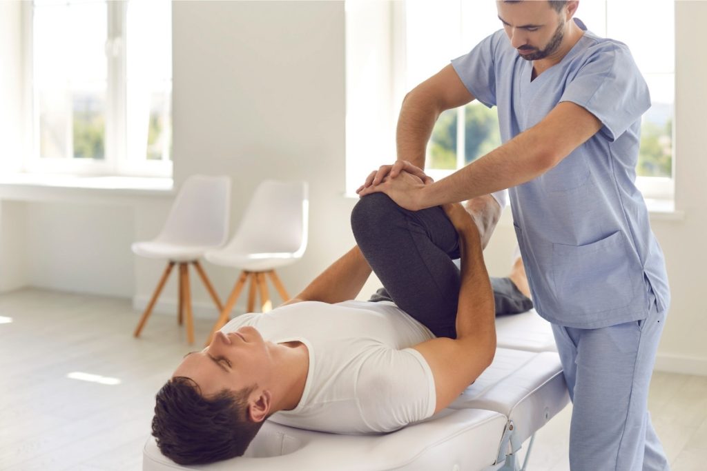 Male physical therapist treating a male client
