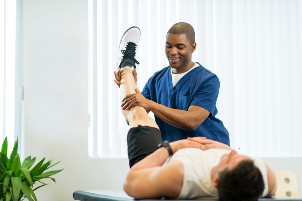 Male physical therapist treating male client