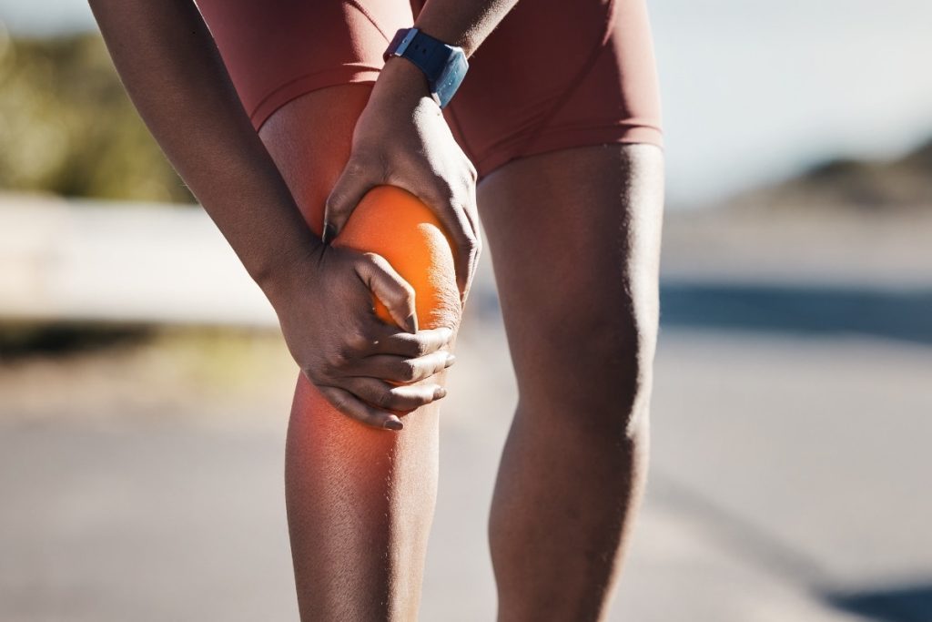 Runner holding knee in pain