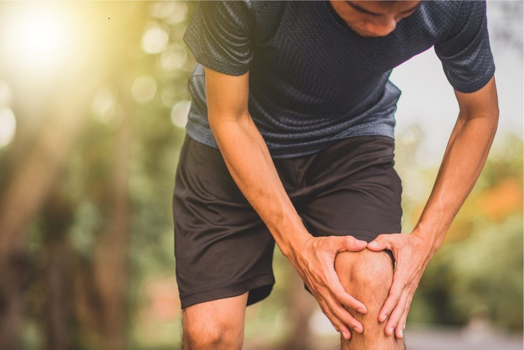 Runner holding knee pain