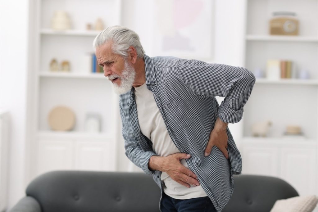 Adult holding left hip in pain