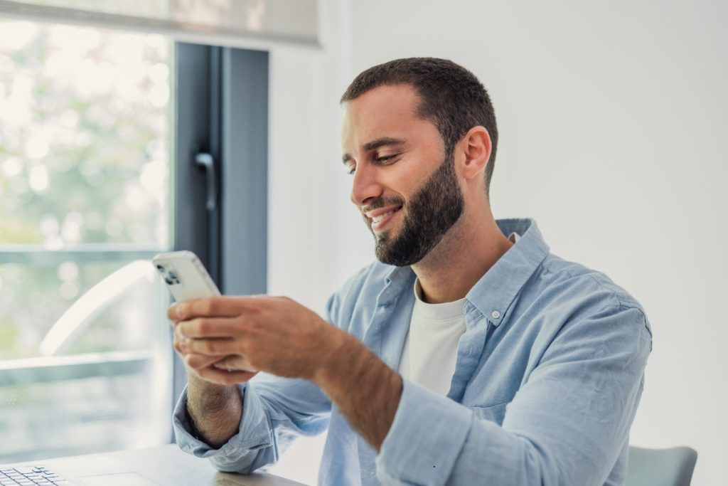 Man smiling using phone