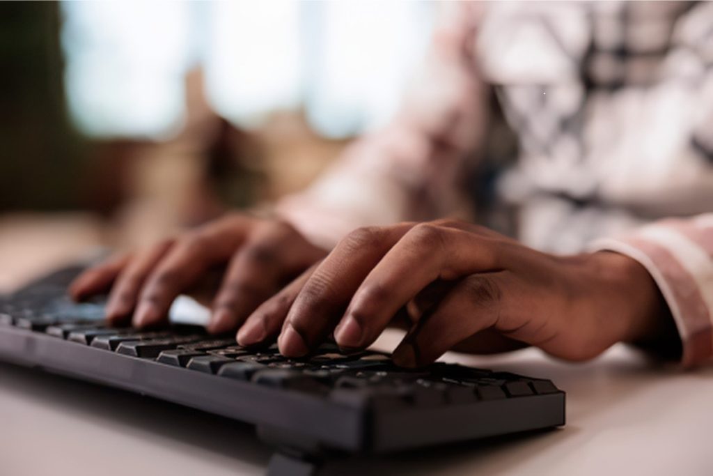 Person's hands typing on keyboard